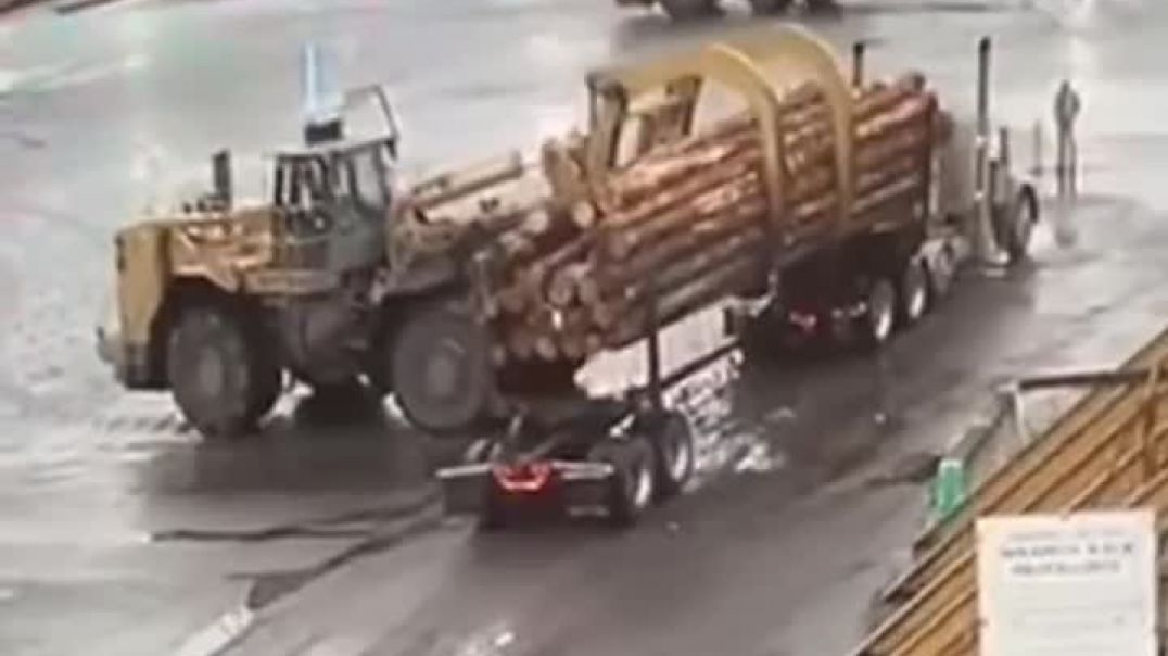 ⁣Loader turns over log truck